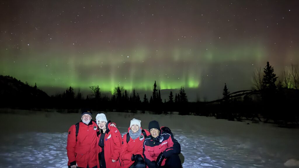 Cuatro personas tomando fotografías con las Auroras boreales
